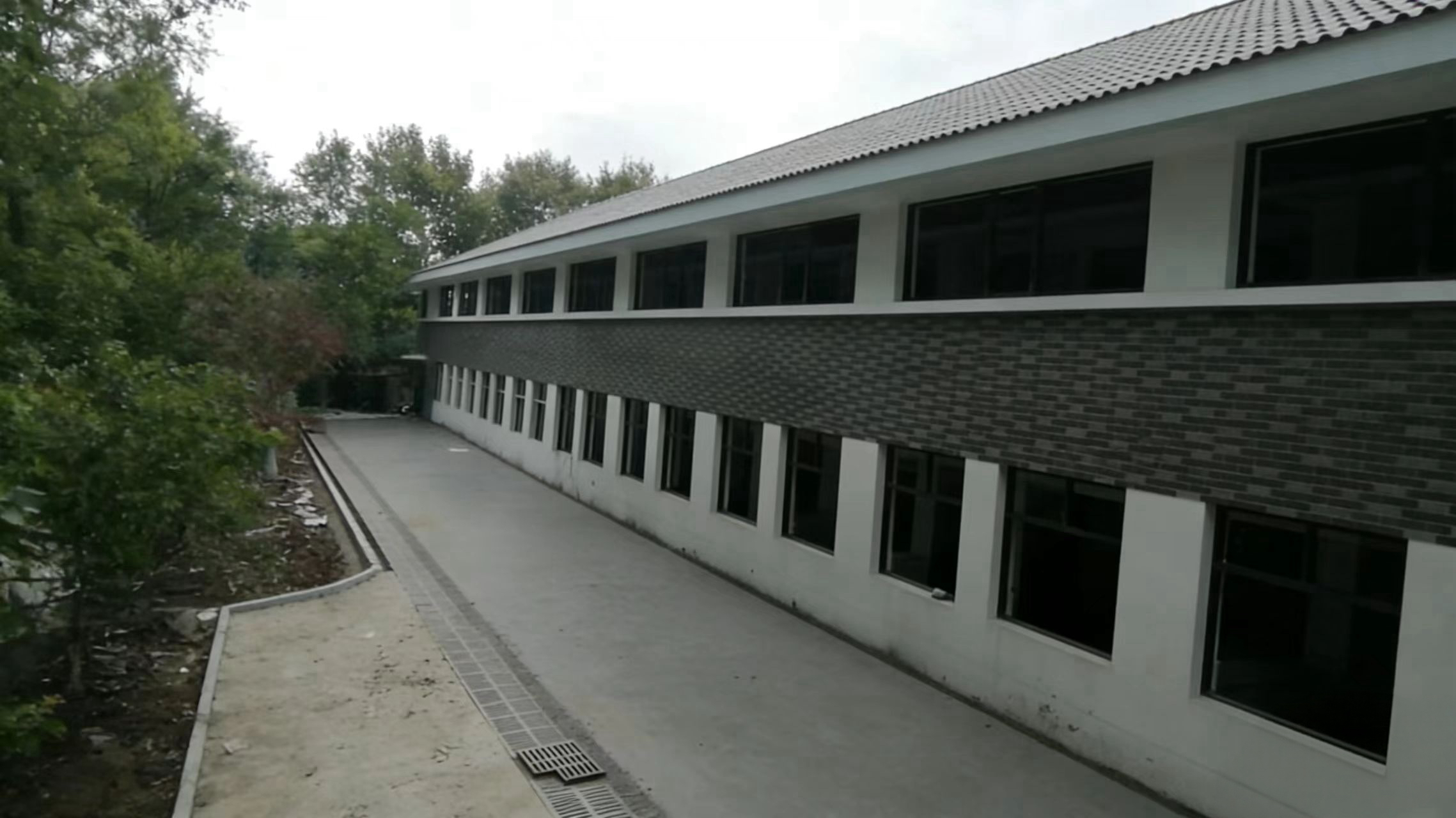 学校教学楼建筑外观，红砖外墙配白色窗框，校园环境优美